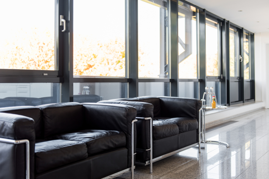 Helle Unternehmenslounge von Docmedicus IT mit modernen Ledersesseln und großen Fensterfronten