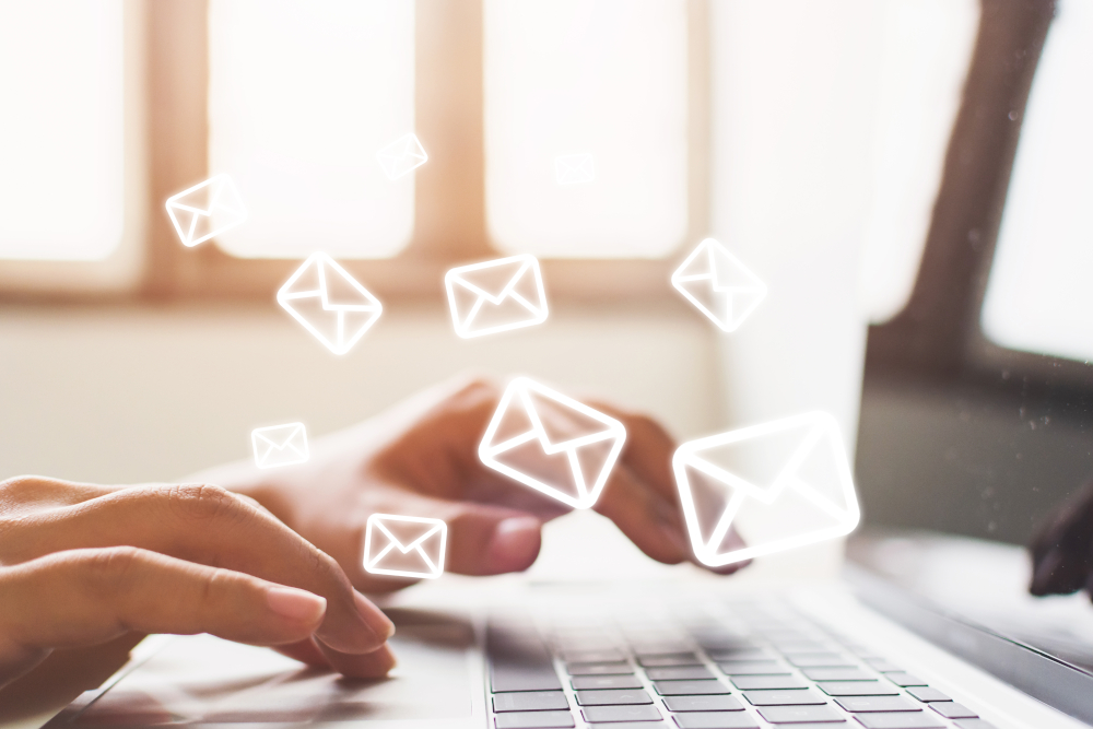 Hände auf Laptop-Tastatur mit E-Mail-Symbolen – digitale Kommunikation und Newsletter-Marketing von Docmedicus IT